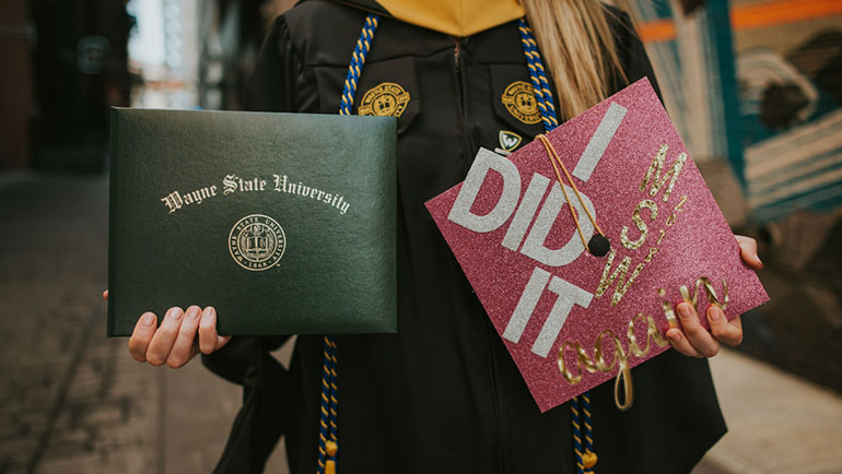 Wayne State graduate with her diploma and cap