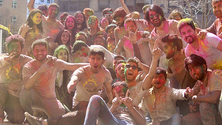 Students covered in colorful dye celebrate Holi