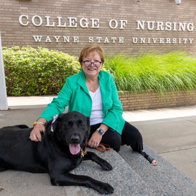 Bella sitting with Dean Clabo at the College of Nursing